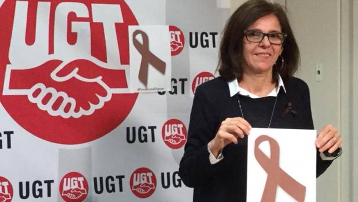 Higinia García, secretaria de Política Sindical de UGT Castilla-La Mancha, muestra el lazo marrón