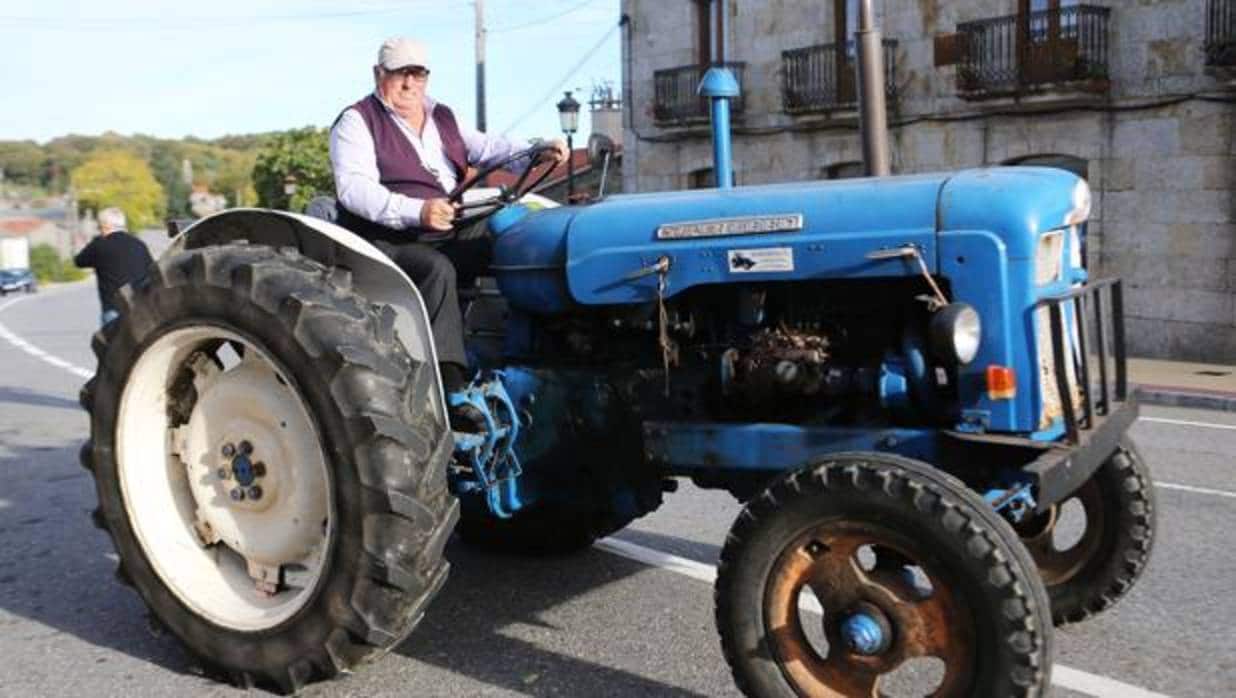 Un vecino de Dozón (Pontevedra) circula con su tractor por las calles del pueblo