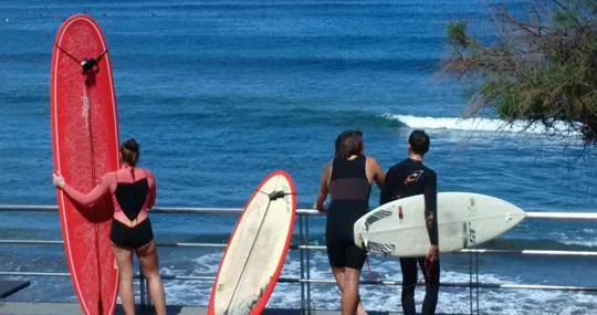 Surfistas meditando sobre si lanzarse o no en Las Canteras este domingo