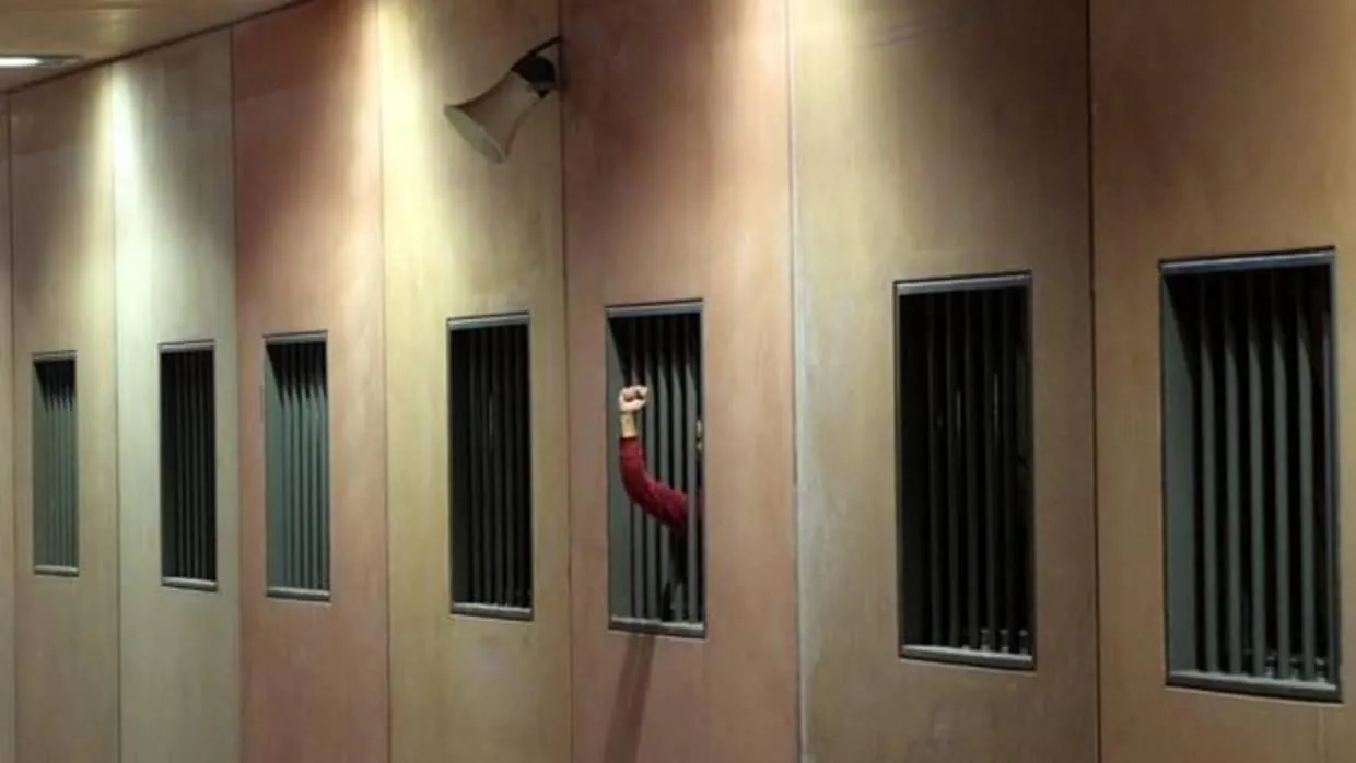 Un preso asoma su brazo entre los barrotes de su celda