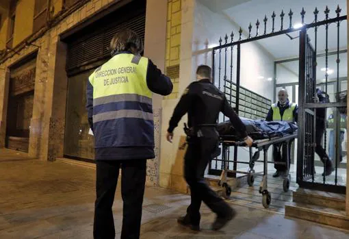 Miembros del Retén Funebre y agentes del Cuerpo Nacional de Policía retiran los restos humanos hallados en el interior de una vivienda situada en la calle de Vicente Zaragozà del del barrio valenciano de Benimaclet