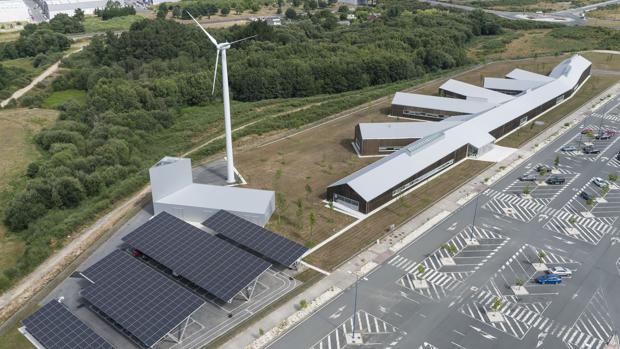 Vista aérea del edificio, donde se distinguen las plantas fotovoltáicas y el aerogenerador