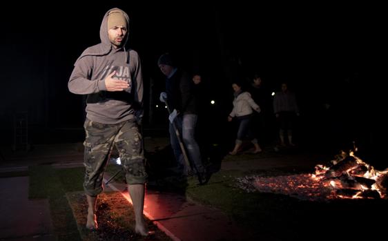 Uno de los asistentes camina sobre brasas ardiendo