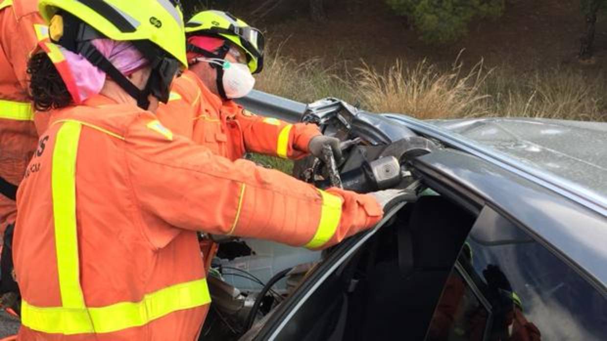 Efectivos de Bomberos excarcelando a una persona del coche implicado en el accidente