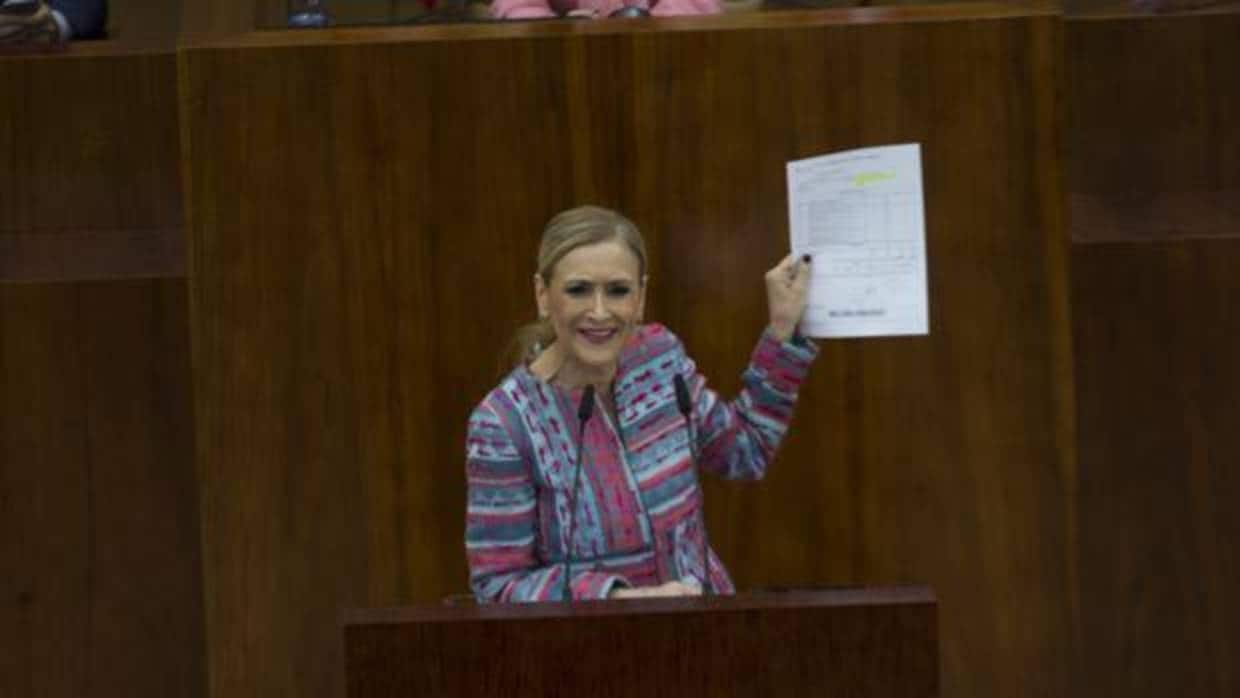 Cristina Cifuentes, en el pleno de la Asamblea de Madrid, mostrando la matrícula de su máster