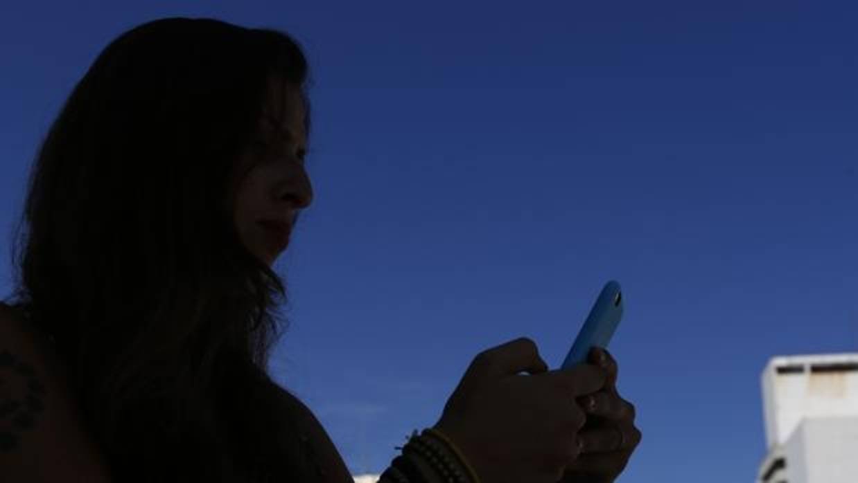 Una mujer mira su teléfono móvil en una imagen de archivo