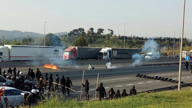 Estudiantes encapuchados cortan la autopista y queman neumáticos contra las tasas universitarias