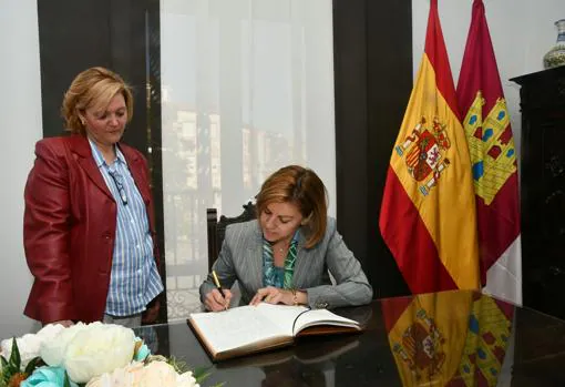 Cospedal firma en el libro de honor en presencia de Marina García