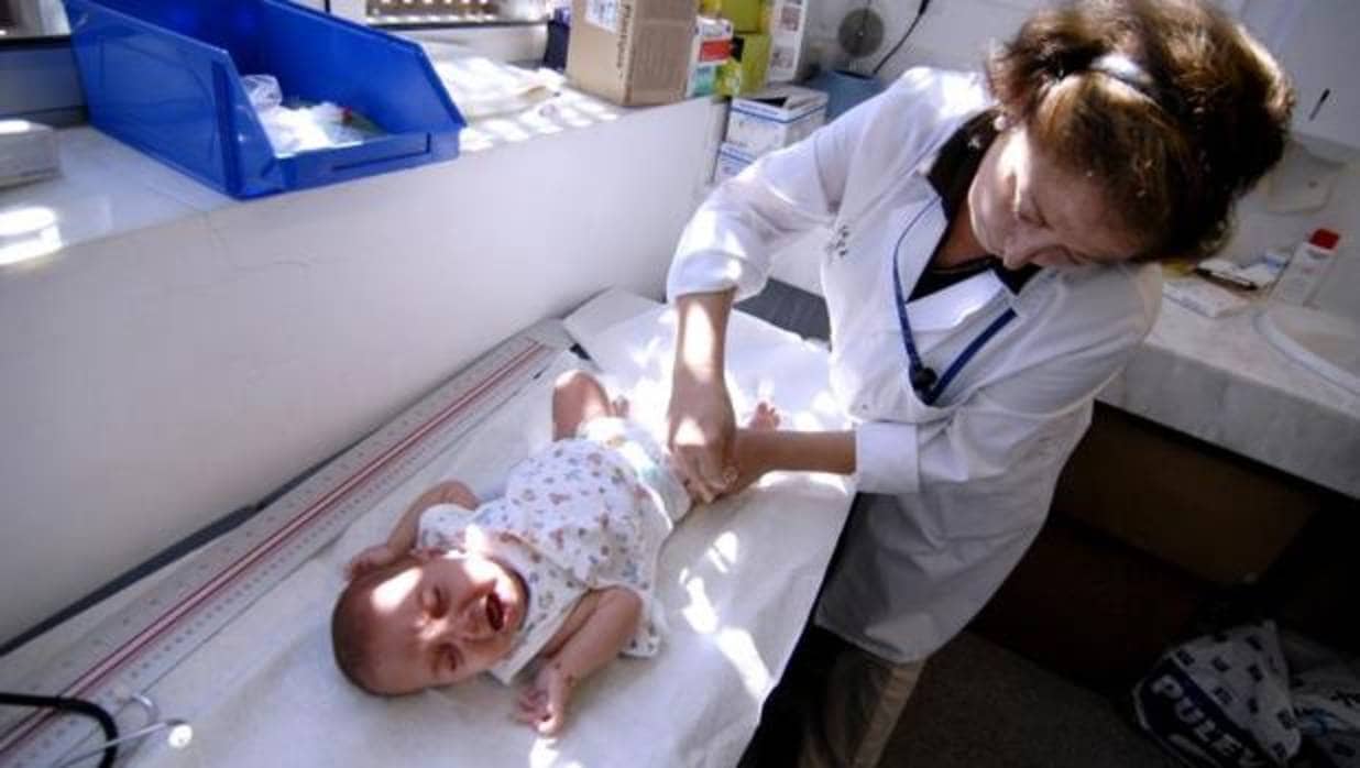 Una pediatra administrando una vacuna a un bebé