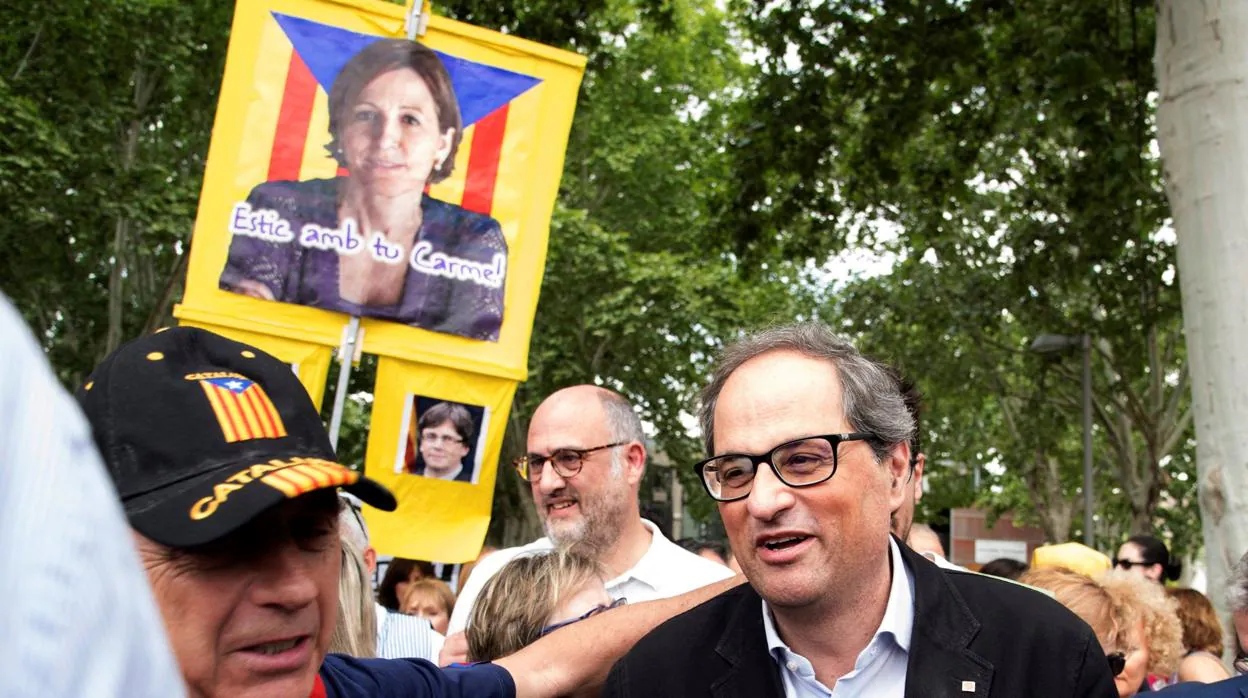 El presidente catalán Quim Torra con una pancarta con el rostro de la expresidenta de la ANC detrás