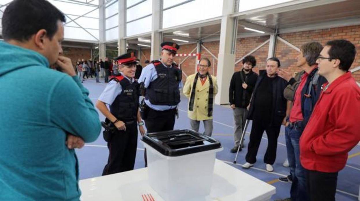Varios Mossos esperan al recuento de votos para retirar las urnas durante el 1-O