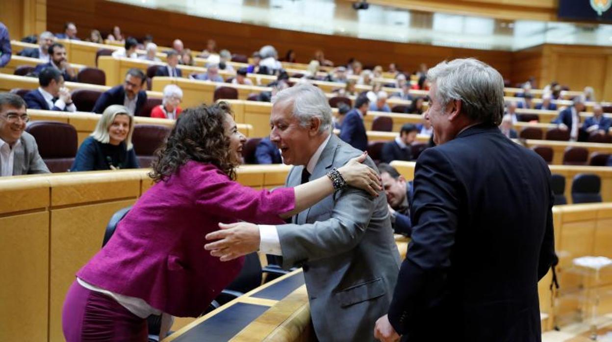 La ministra de Hacienda, María Jesús Montero saluda al vicesecretario de Política Autonómica y Local del PP, Javier Arenas, hoy en el Senado