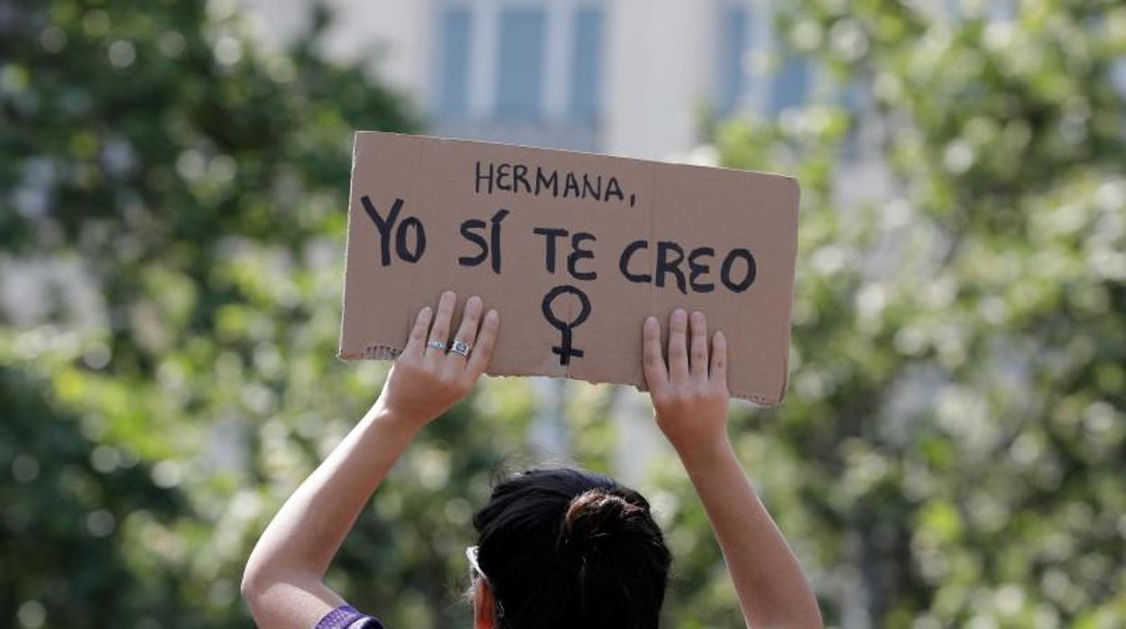Una manifestante levanta un cartel en apoyo a la joven de la que abusaron