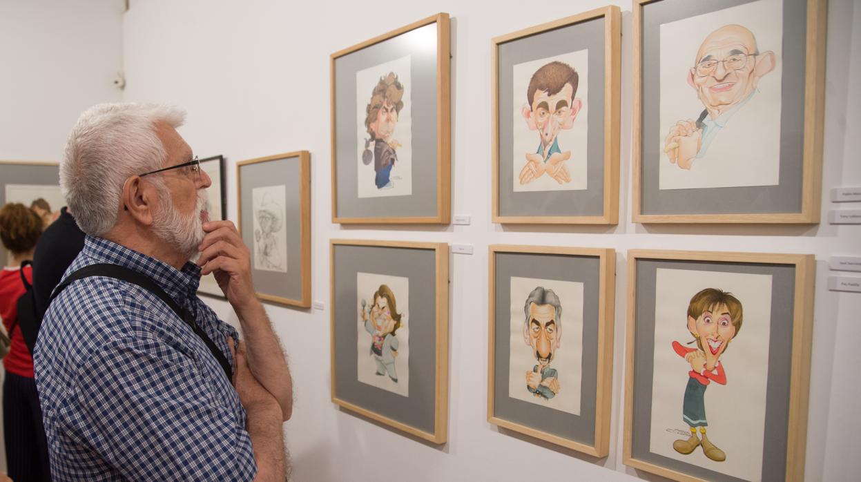 Un hombre observa las caricaturas expuestas