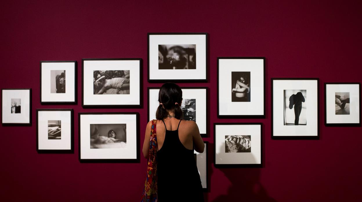 Una visitante contempla un grupo de fotografías expuestas en Foto Colectania