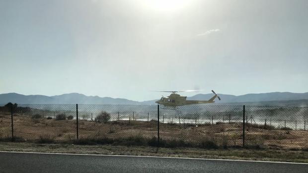 Medios aéreos y terrestres sofocan un incendio junto a una zona industrial en Ibi