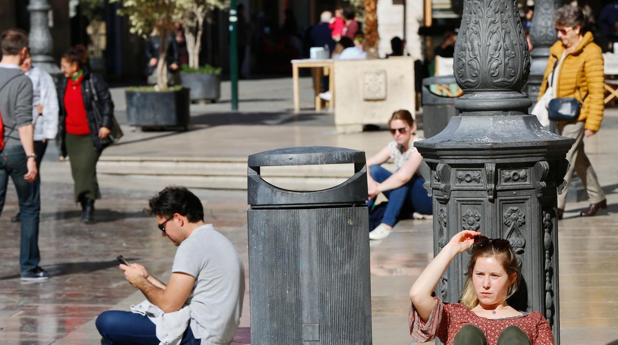 Imagen de una joven tomando el sol en centro de valencia debido al calor extremo