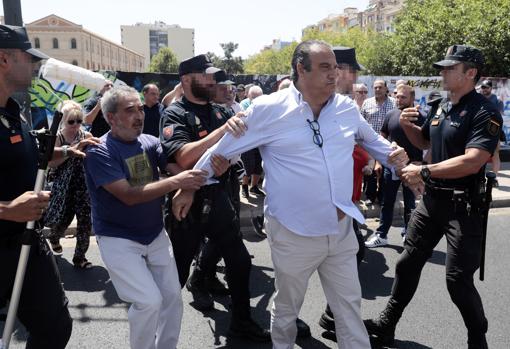 Imagen del presidente de la Federació Coordinadora d'Entitats Culturals del Regne de Valencia (FCECRV), Juan García Sentandreu, apartado por agentes de la Policía Nacional