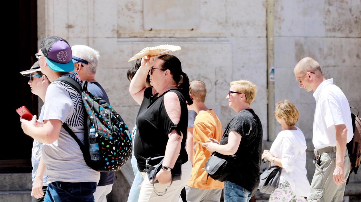 Imagen de un grupo de turistas pasando calor en el centro de Valencia