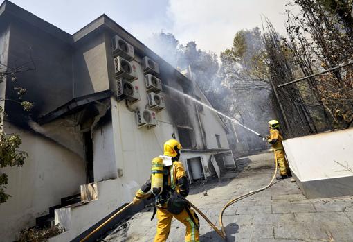 Imagen de bomberos apagando el fuego de una casa afectada por el incendio