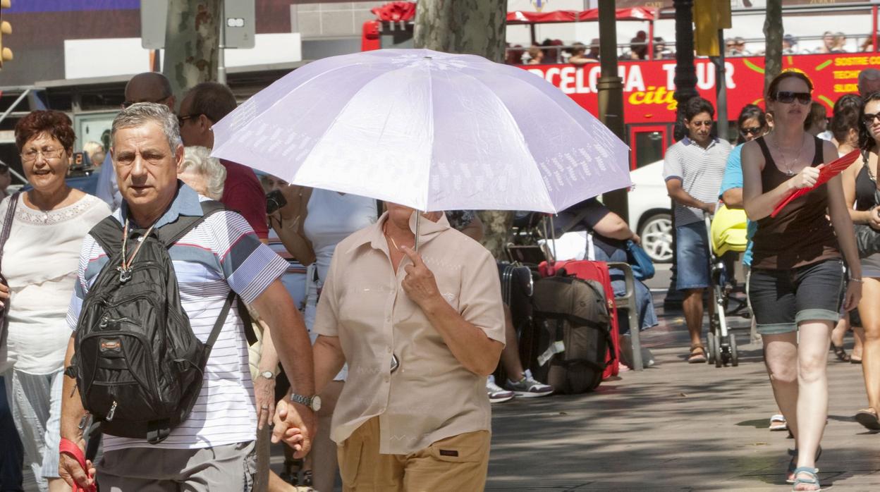 Una pareja bajo un paraguas por el centro de Barcelona