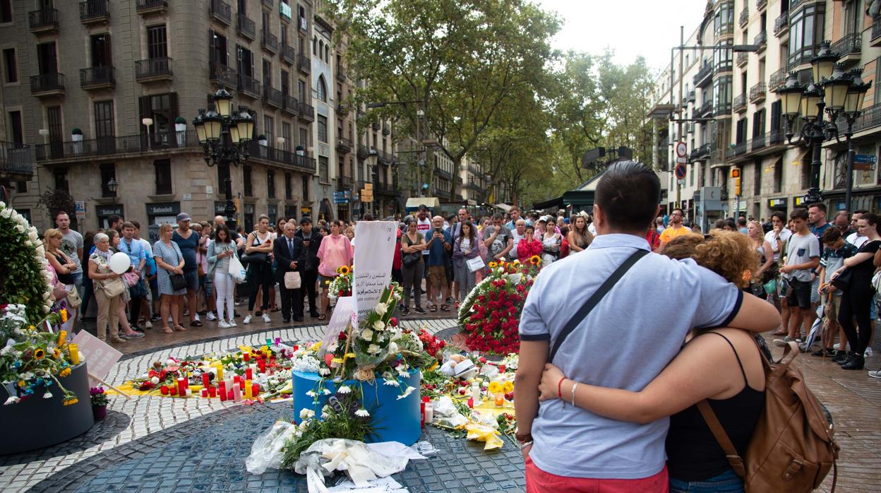 Una pareja se abraza frente al mosaico de Miró, en las Ramblas, a la misma hora en la que, hace un año, se produjo el atentado