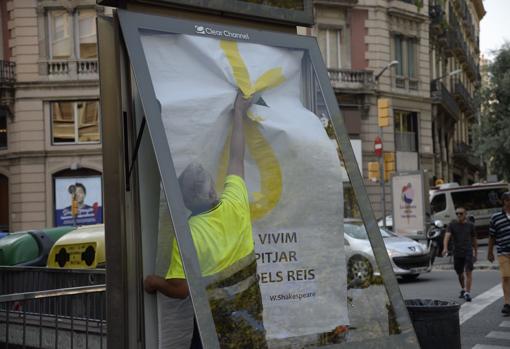 Momento en el que un operario retira uno de los polémicos carteles