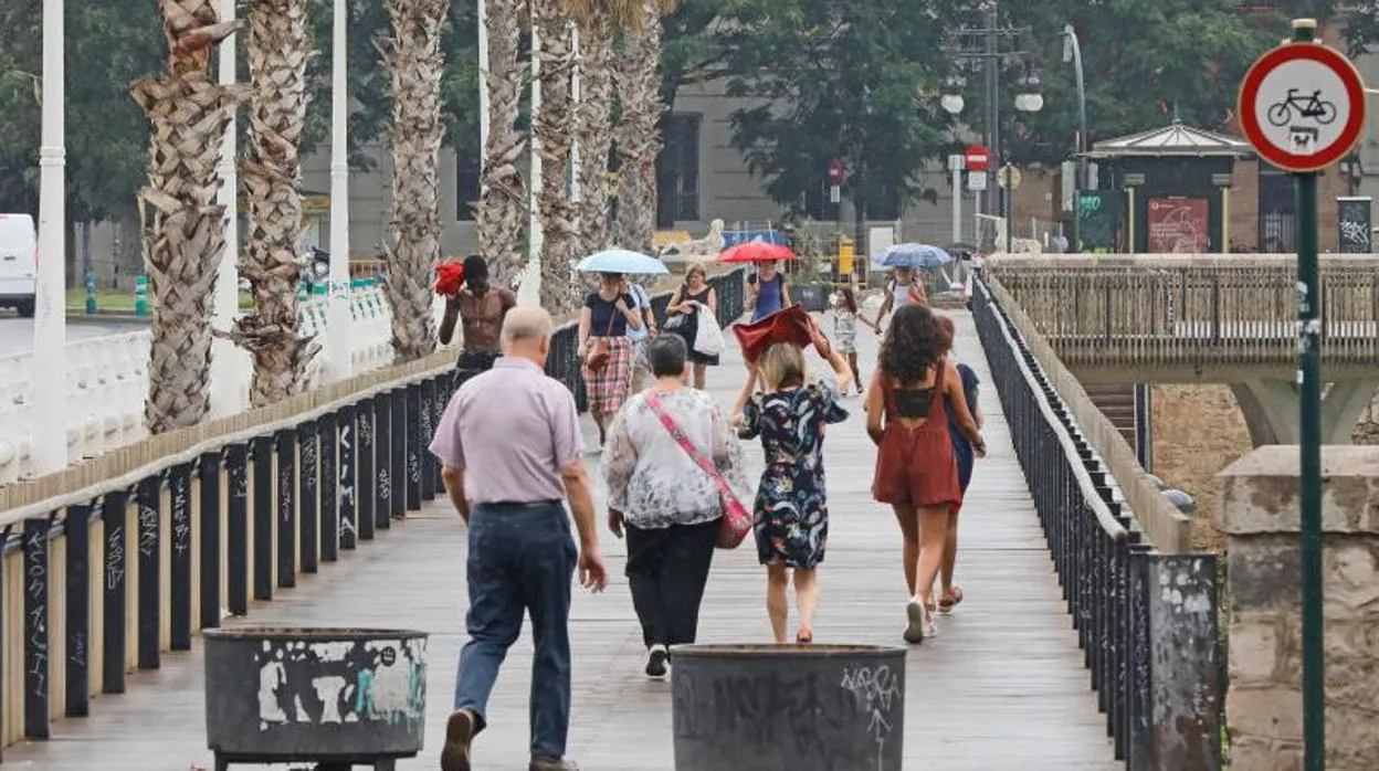 Transeúntes se protegen de la lluvia en Valencia