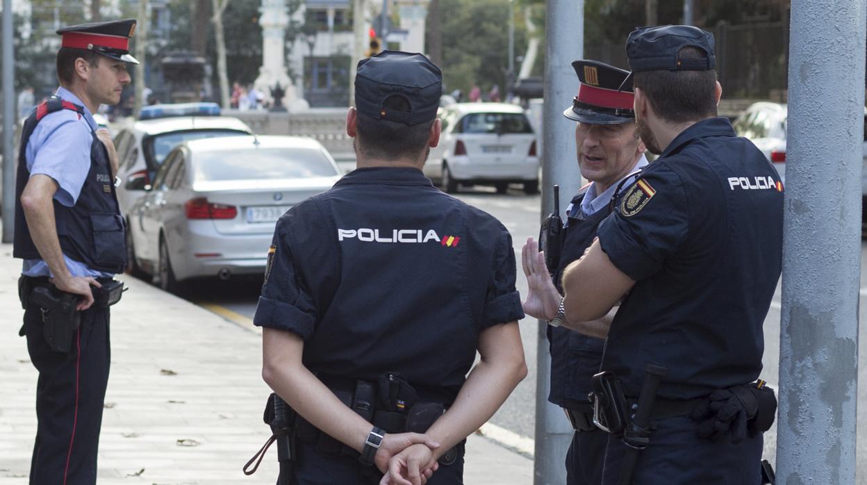 Agentes de la Policía hablan con efectivos de los Mossos en Barcelona