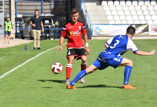 Un futbolista blanquiazul intenta interponerse en la trayectoria del esférico