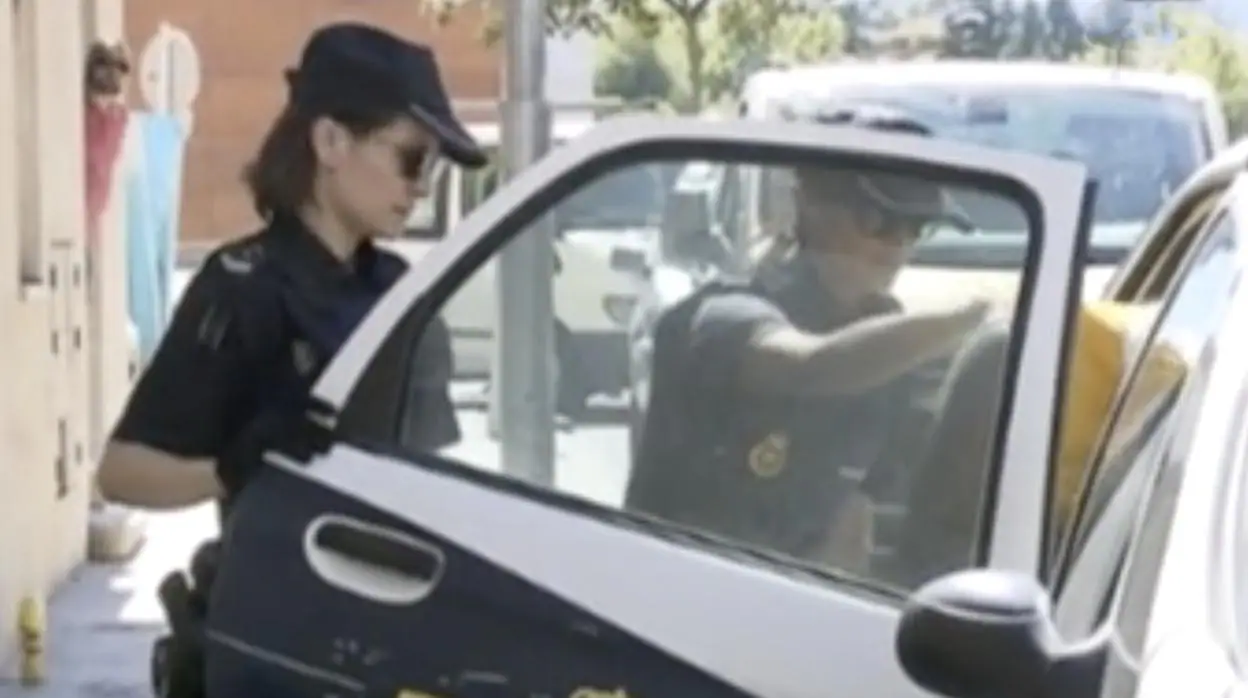 Momento en que dos agentes introducen al acusado en un coche patrulla para trasladarle a prisión
