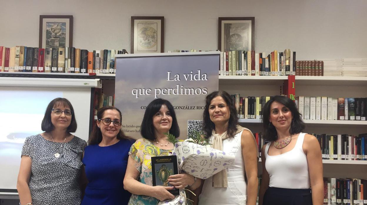 Consolación González Rico, en el centro, con un ramo de flores entregado por la alcaldesa, Elena Fernández, y un libro sobre la historia de Villasequilla