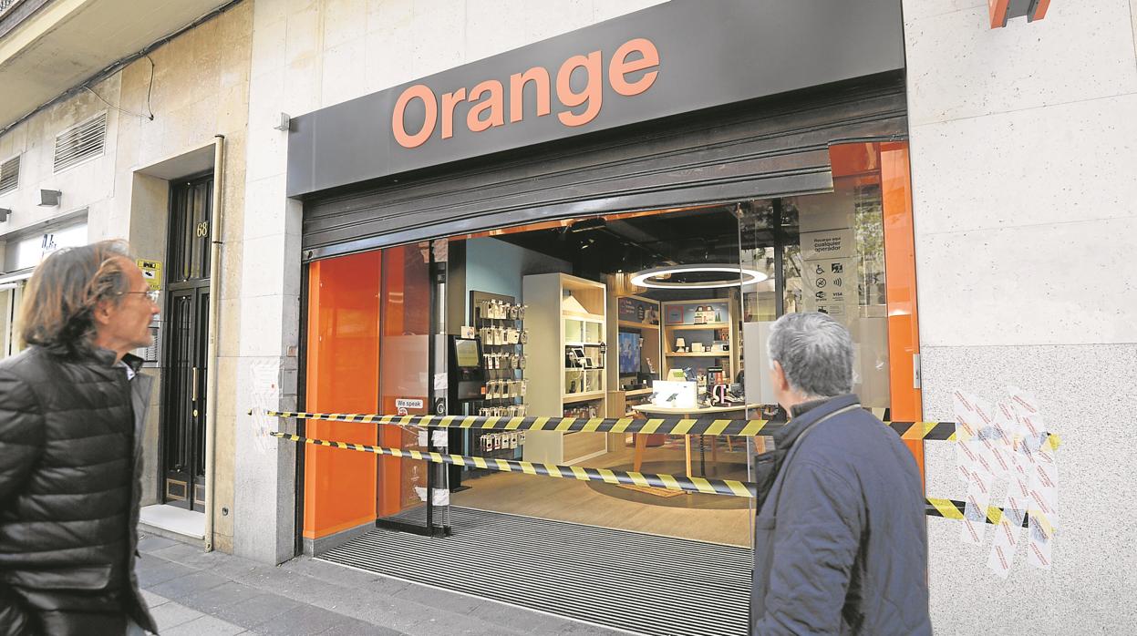 La entrada de la tienda Orange asaltada ayer, precintada, en Alberto Aguilera, 58