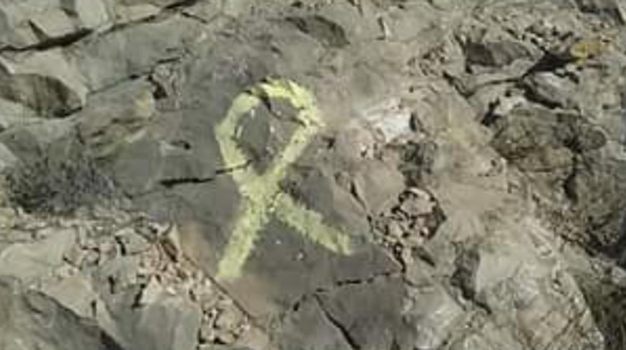 Lazo amarillo pintado sobre la roca en la Sierra del Cid de Petrer (Alicante)
