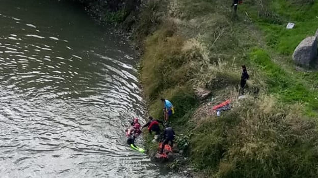 Momento en que bomberos y policías sacan a la mujer del río