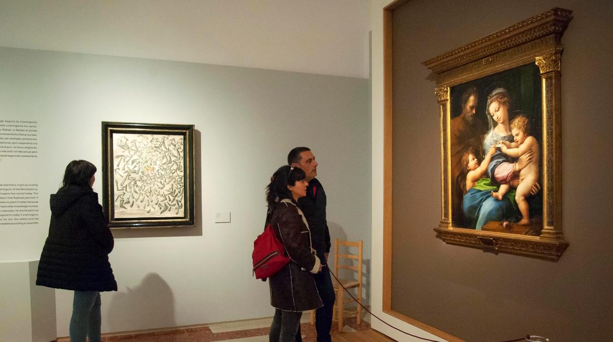 Varios visitantes contemplan la exposición «Dalí-Rafael, una prolongada ensoñación»