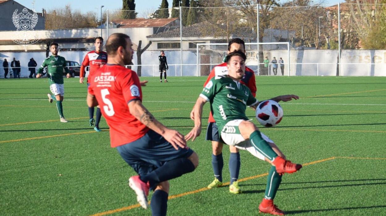 El futbolista del CD Toledo Iván Bueno trata de controlar el balón entre dos jugadores del Villacañas