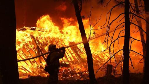 Bombero apagando el fuego que ya había quemado una vivienda