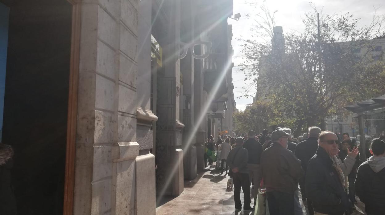 Imagen de una cola frente a una administración de loterías del centro de Valencia