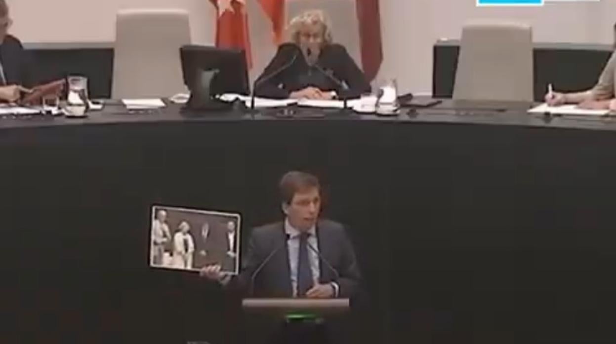 Martínez-Almeida, en el pleno del Ayuntamiento, con la foto de Carmena, Puigdemont, Romeva y Junqueras