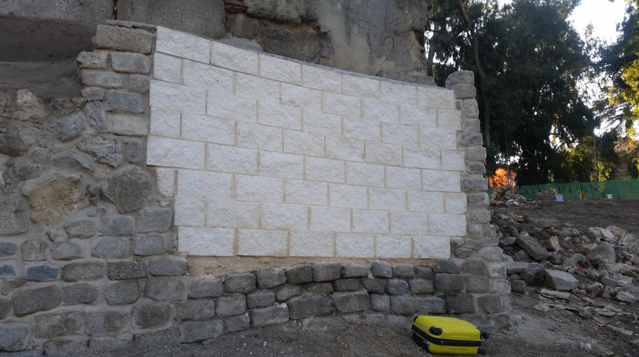 Remates con bloques de hormigón blanco en un muro histórico protegido del siglo XIX, junto al Palacio Real