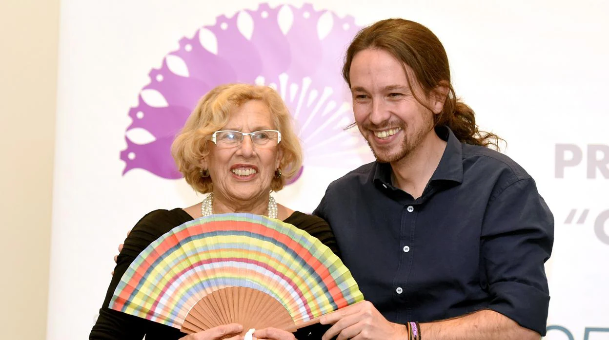 El secretario general de Podemos, Pablo Iglesias, le entrega un premio a Manuela Carmena, en 2015