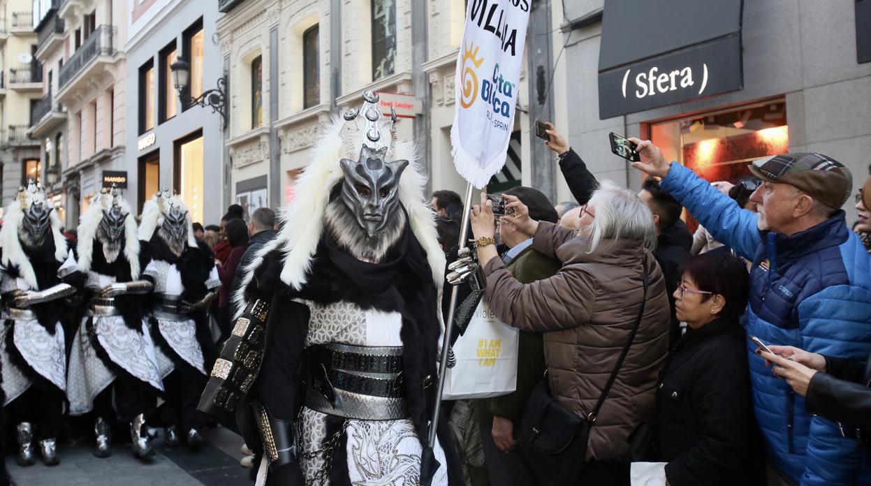 Espectadores del desfile en las calles de Madrid fotografían las fiestas alicantinas