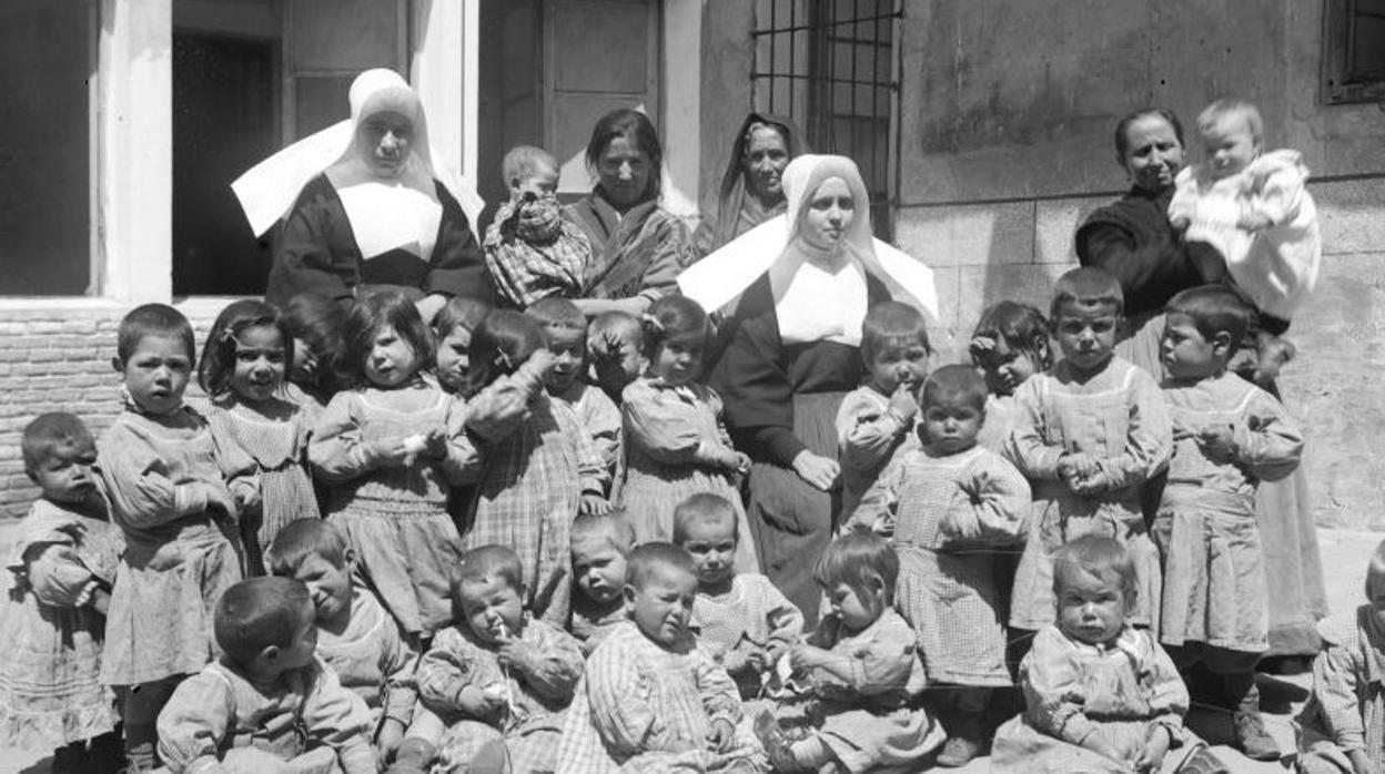 Grupo de niños con monjas y nodrizas en uno de los patios del Asilo (Fondo Santiago Relanzón. Archivo Municipal de Toledo)