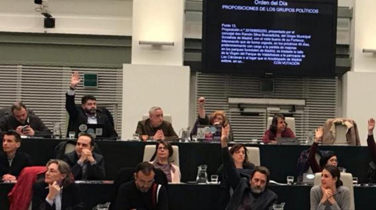 Los concejales de Ahora Madrid alzan la mano para votar en el pleno