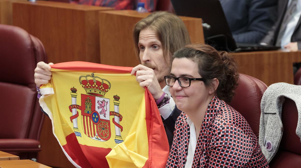 El líder de Podemos en Castilla y León, Pablo Fernández, muestra a Herrera la bandera de España