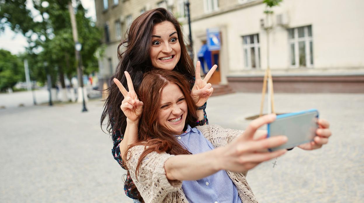 Dos chicas se hacen un selfie en la calle