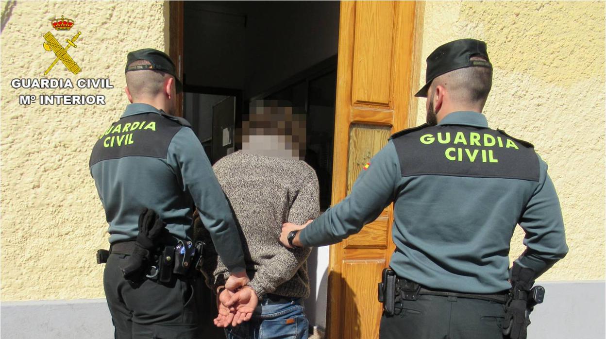 El detenido, custodiado por dos guardias civiles