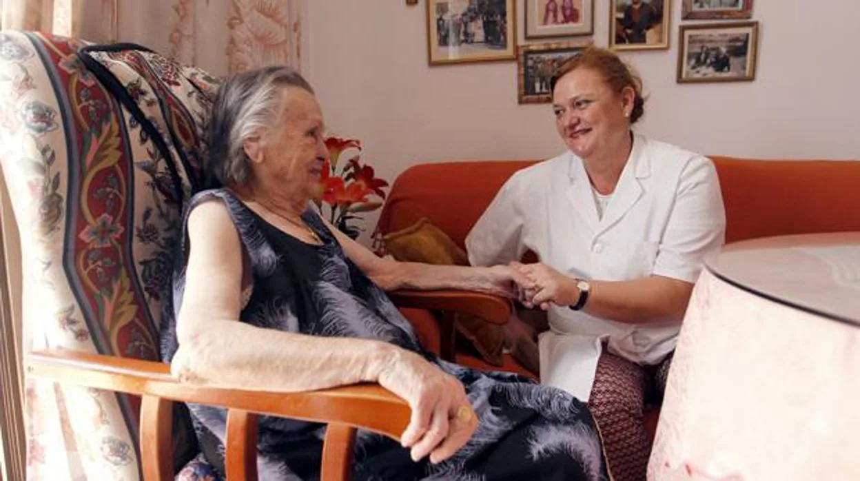 Una trabajadora social atiende a una persona mayor dentro del servicio de ayuda a domicilio