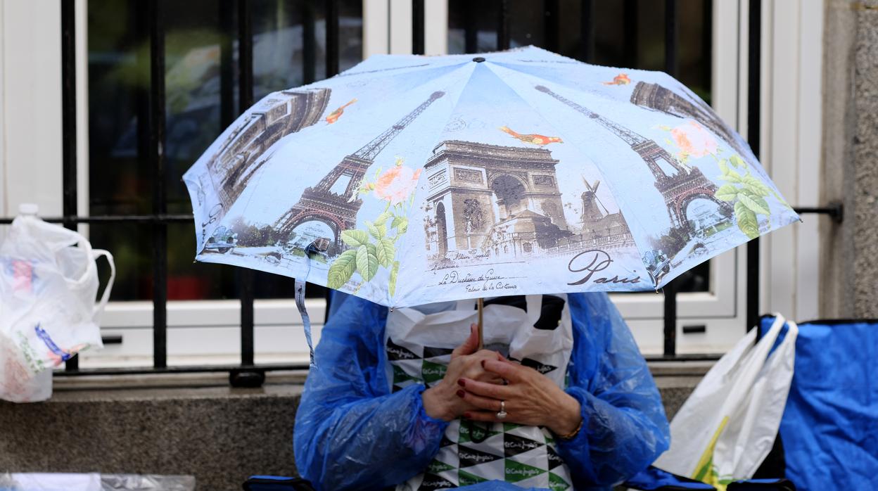 Una mujer sujeta un paraguas para resguardarse de la lluvia en la capital